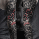 CNX Tattoo Plattenspieler Trash-Polka Schwarz Rot Farbklecksen Tattoo Arm von CNX Tattoo Berlin Prenzlauer Berg