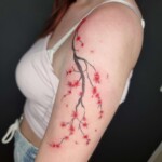 Kirschblüten rot-Schwarz Mikrorealismus Filigran Tattoo Oberarm von CNX Tattoo Berlin Prenzlauer Berg